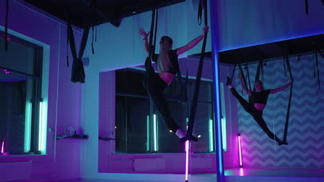 fly-yoga-training-for-stretching-legs-woman-is-doing-split-in-hammock-above-floor-aerial-yoga